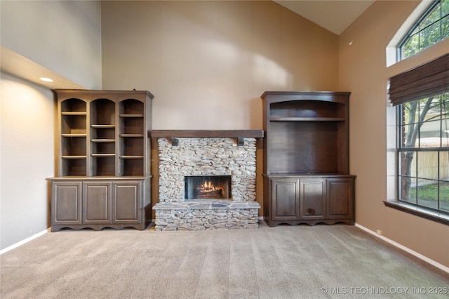 10511 S 83rd Cir, Tulsa, OK 74133 - unfurnished living room featuring high vaulted ceiling, carpet floors, baseboards, and a stone fireplace
