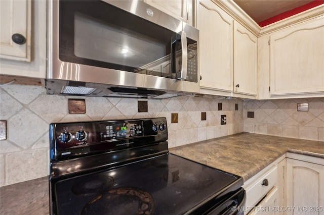 10511 S 83rd Cir, Tulsa, OK 74133 - kitchen with black range with electric cooktop, stainless steel microwave, cream cabinetry, and decorative backsplash