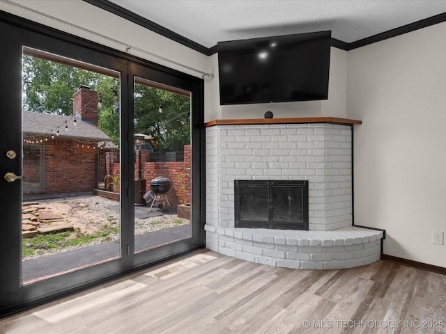 2318 Dorchester Dr, Bartlesville, OK 74006 - unfurnished living room featuring ornamental molding, wood finished floors, healthy amount of natural light, a brick fireplace, and baseboards