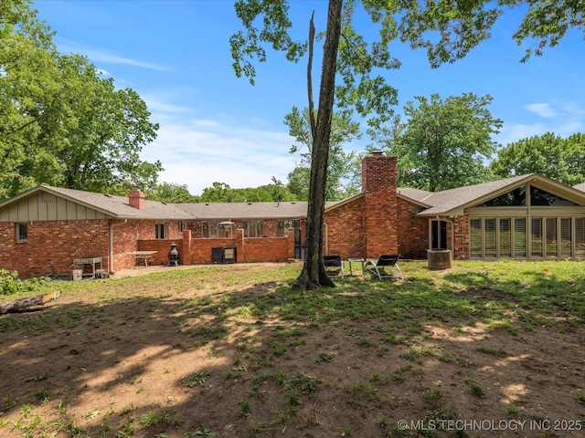 2318 Dorchester Dr, Bartlesville, OK 74006 - back of property featuring a chimney and brick siding