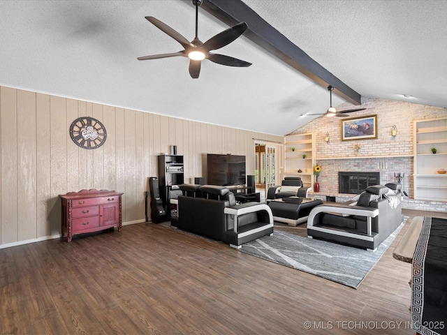 2318 Dorchester Dr, Bartlesville, OK 74006 - living area featuring a ceiling fan, wood finished floors, a textured ceiling, a fireplace, and wooden walls