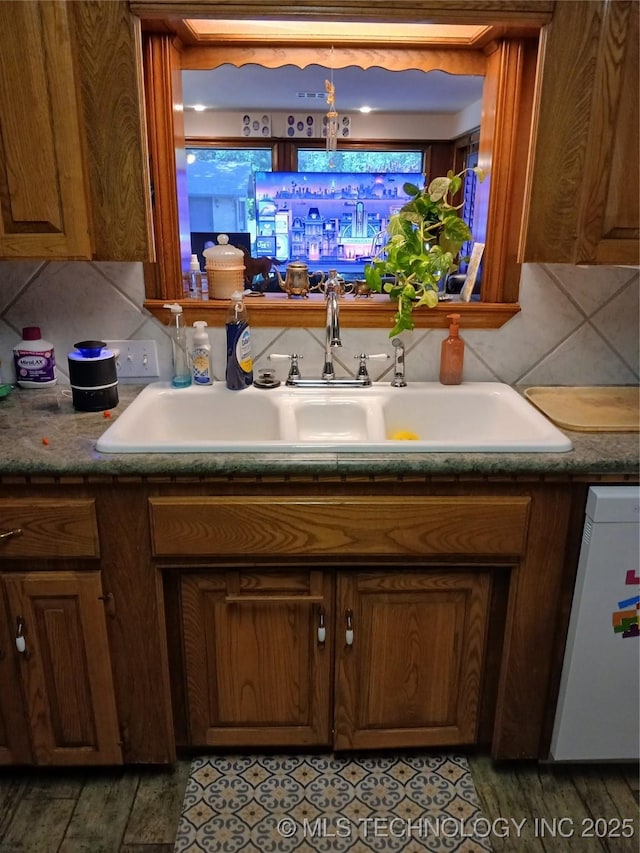 715 Kiowa, Hartshorne, OK 74547 - kitchen with a sink, brown cabinets, white dishwasher, and tasteful backsplash