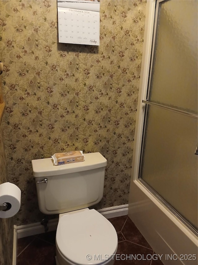 715 Kiowa, Hartshorne, OK 74547 - bathroom featuring tile patterned flooring, baseboards, toilet, wallpapered walls, and bath / shower combo with glass door