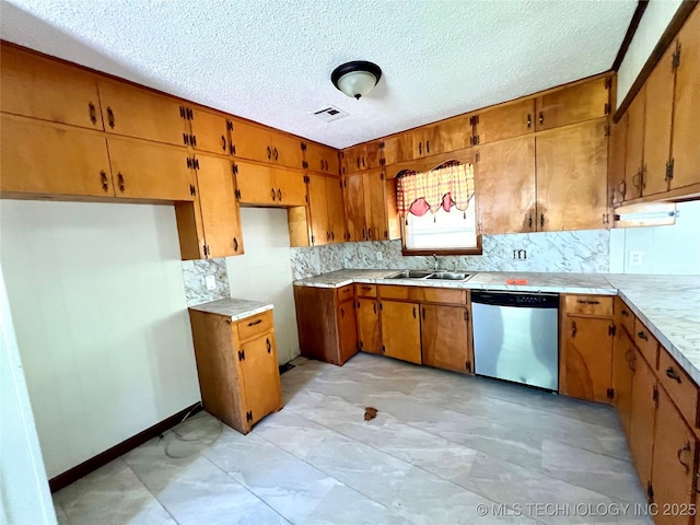 503 NE 4th St, Stigler, OK 74462 - kitchen with stainless steel dishwasher, a sink, brown cabinets, tasteful backsplash, and light countertops