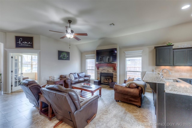10216 N 120th E Ave, Owasso, OK 74055 - living area with healthy amount of natural light, a ceiling fan, lofted ceiling, a stone fireplace, and recessed lighting