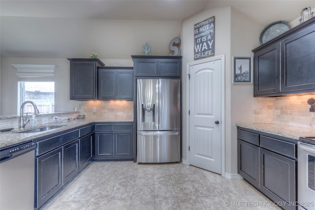 10216 N 120th E Ave, Owasso, OK 74055 - kitchen with stainless steel appliances, a sink, light stone counters, and tasteful backsplash