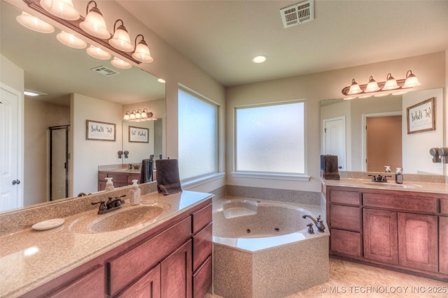10216 N 120th E Ave, Owasso, OK 74055 - bathroom featuring two vanities, a jetted tub, and recessed lighting