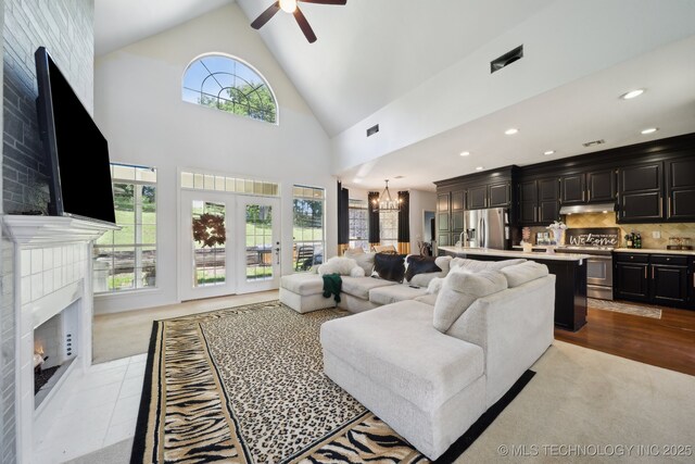 4602 S Linwood Dr, Sand Springs, OK 74063 - living area with a chandelier, healthy amount of natural light, a ceiling fan, high vaulted ceiling, and a tiled fireplace