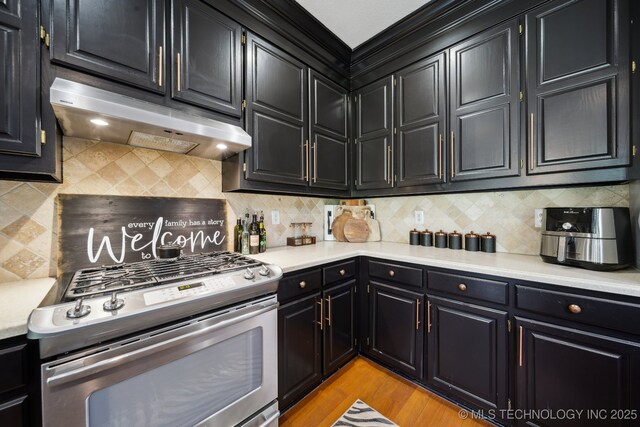4602 S Linwood Dr, Sand Springs, OK 74063 - kitchen with stainless steel range with gas cooktop, under cabinet range hood, dark cabinetry, and light countertops