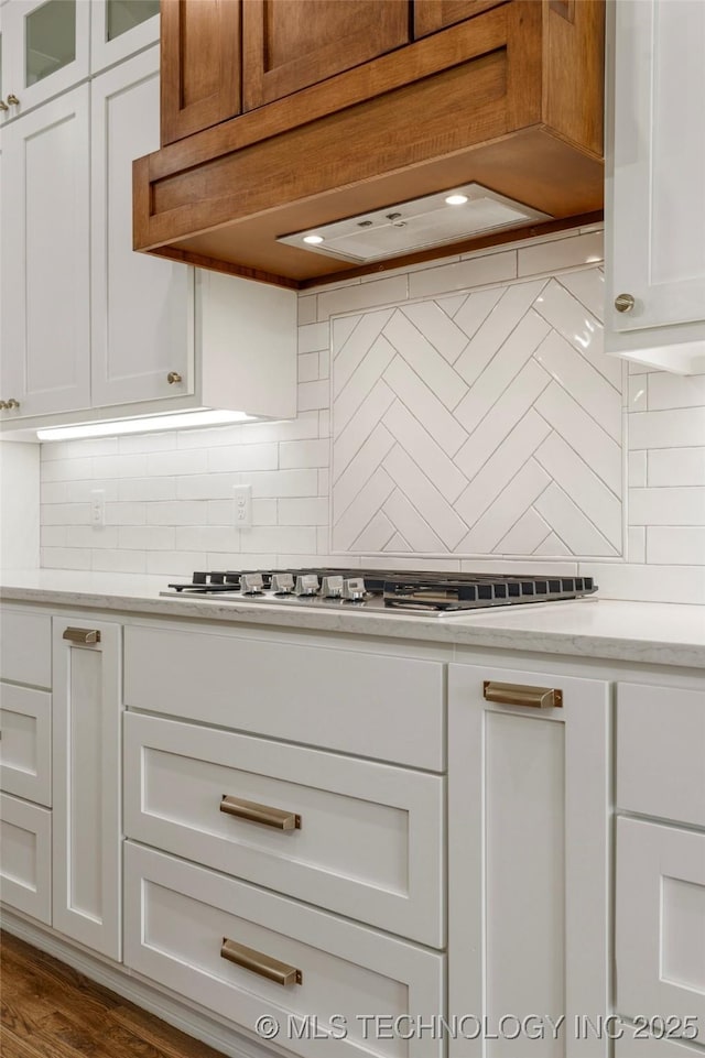 2978 E 146th St S, Bixby, OK 74008 - kitchen featuring decorative backsplash, white cabinets, glass insert cabinets, stainless steel gas cooktop, and premium range hood