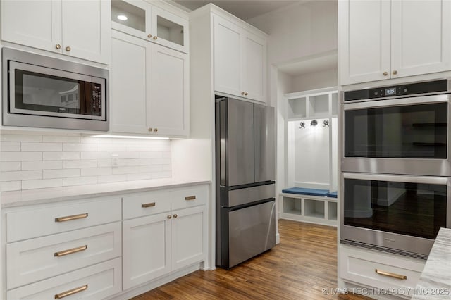 2978 E 146th St S, Bixby, OK 74008 - kitchen with appliances with stainless steel finishes, white cabinets, tasteful backsplash, dark wood finished floors, and glass insert cabinets