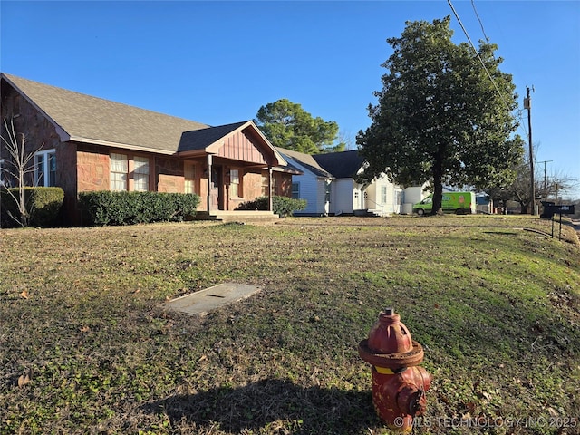 1324 N 3rd, Durant, OK 74701 - view of front of home with board and batten siding, a front lawn, and stone siding
