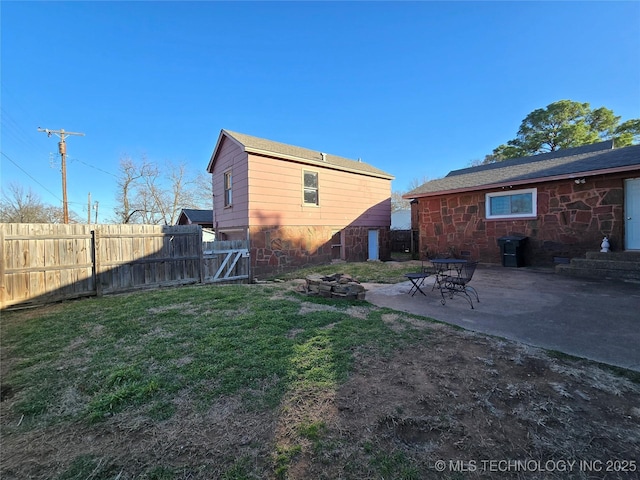 1324 N 3rd, Durant, OK 74701 - rear view of property featuring stone siding, a patio, and an outdoor fire pit