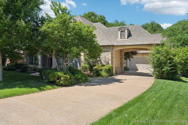 3335 E 93rd St, Tulsa, OK 74137 - french provincial home featuring stone siding, driveway, a front lawn, and roof with shingles