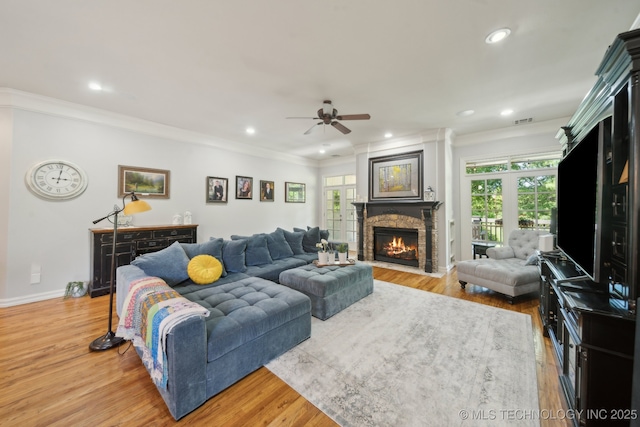 3335 E 93rd St, Tulsa, OK 74137 - living room with a stone fireplace, crown molding, ceiling fan, light wood-style floors, and recessed lighting