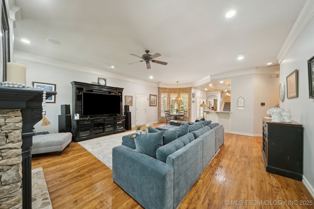 3335 E 93rd St, Tulsa, OK 74137 - living area with a ceiling fan, light wood-style flooring, recessed lighting, crown molding, and a stone fireplace