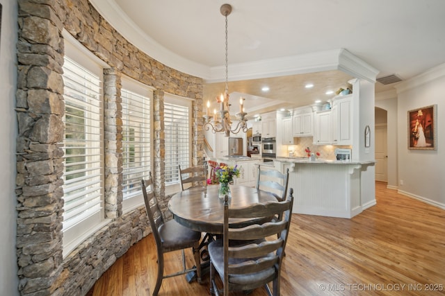 3335 E 93rd St, Tulsa, OK 74137 - dining area with crown molding, a chandelier, light wood-style flooring, and arched walkways