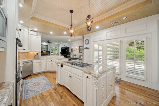 3335 E 93rd St, Tulsa, OK 74137 - kitchen featuring ornamental molding, stainless steel appliances, a tray ceiling, open floor plan, and a chandelier
