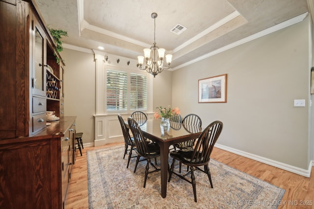 3335 E 93rd St, Tulsa, OK 74137 - dining room with a raised ceiling, a chandelier, light wood-style flooring, baseboards, and crown molding