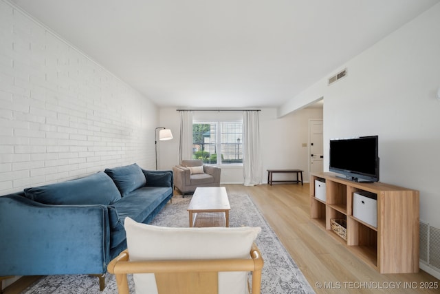 5538 E 46th St Unit 9, Tulsa, OK 74135 - living room featuring brick wall and light wood-style floors