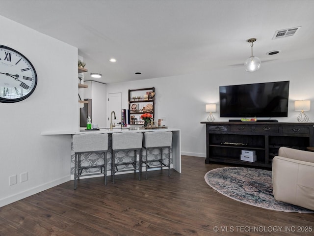 5553 S Delaware Ct, Tulsa, OK 74105 - living room featuring wood finished floors, baseboards, wet bar, and recessed lighting