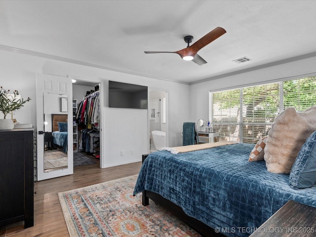 5553 S Delaware Ct, Tulsa, OK 74105 - bedroom featuring a spacious closet, wood finished floors, ornamental molding, ensuite bath, and ceiling fan
