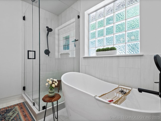 5553 S Delaware Ct, Tulsa, OK 74105 - bathroom with a stall shower, a freestanding tub, and tile walls