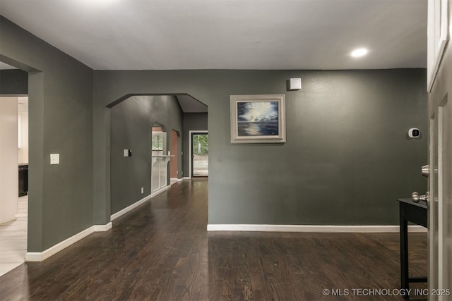 7423 S Urbana Ave, Tulsa, OK 74136 - hall featuring wood finished floors, arched walkways, and baseboards