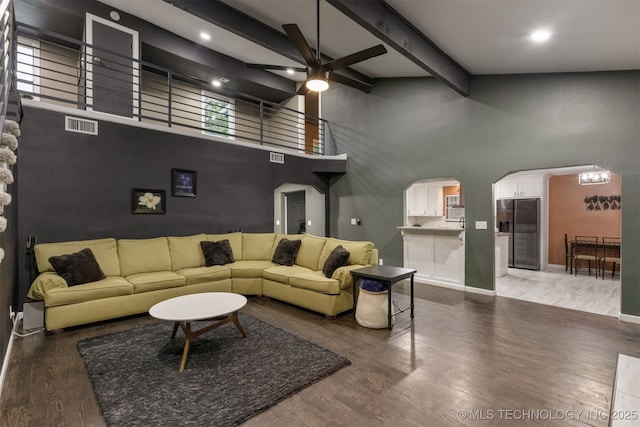 7423 S Urbana Ave, Tulsa, OK 74136 - living room featuring a towering ceiling, ceiling fan, beam ceiling, arched walkways, and wood finished floors