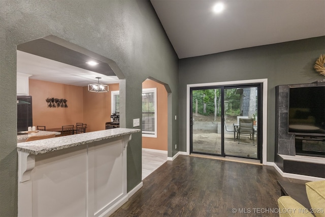 7423 S Urbana Ave, Tulsa, OK 74136 - kitchen featuring wood finished floors, white cabinetry, a chandelier, arched walkways, and high vaulted ceiling