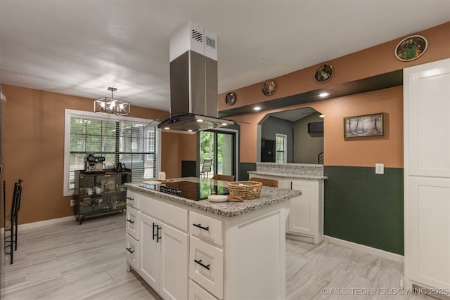 7423 S Urbana Ave, Tulsa, OK 74136 - kitchen featuring a kitchen island, white cabinets, light stone countertops, and island range hood