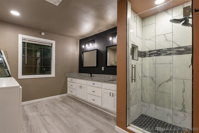 7423 S Urbana Ave, Tulsa, OK 74136 - bathroom with double vanity, a stall shower, wood finished floors, recessed lighting, and baseboards
