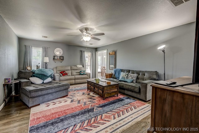 505 Teriwine, Perkins, OK 74059 - living room featuring wood finished floors, a ceiling fan, and a textured ceiling