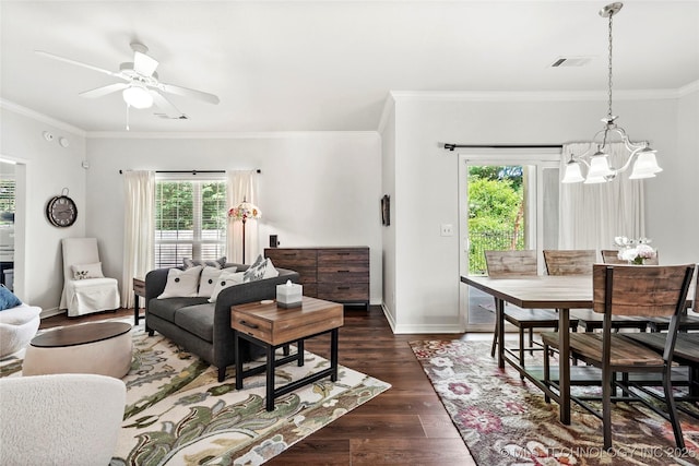 10107 S 94th E Pl, Tulsa, OK 74133 - living room featuring a chandelier, healthy amount of natural light, dark wood-style flooring, ornamental molding, and a ceiling fan