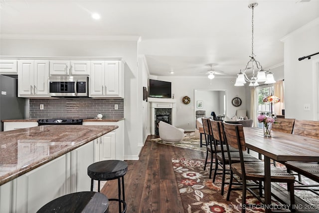 10107 S 94th E Pl, Tulsa, OK 74133 - kitchen featuring stainless steel microwave, a ceiling fan, fridge, crown molding, and decorative backsplash