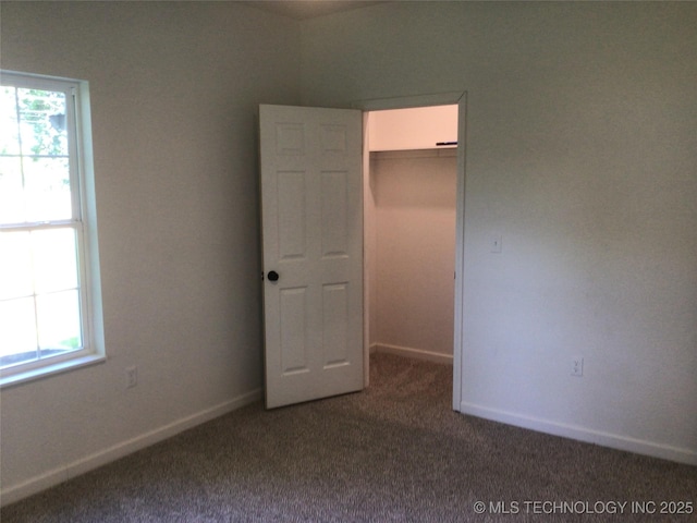 218 N Vann St, Pryor, OK 74361 - unfurnished bedroom with carpet flooring, a walk in closet, a closet, and baseboards