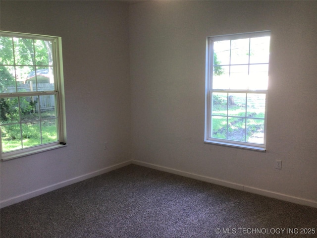 218 N Vann St, Pryor, OK 74361 - empty room featuring healthy amount of natural light, dark colored carpet, and baseboards