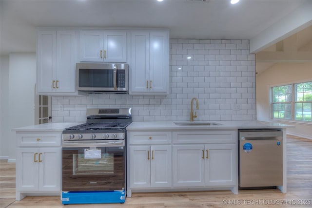 1334 N Nogales Ave, Tulsa, OK 74127 - kitchen with stainless steel appliances, a sink, white cabinets, and backsplash