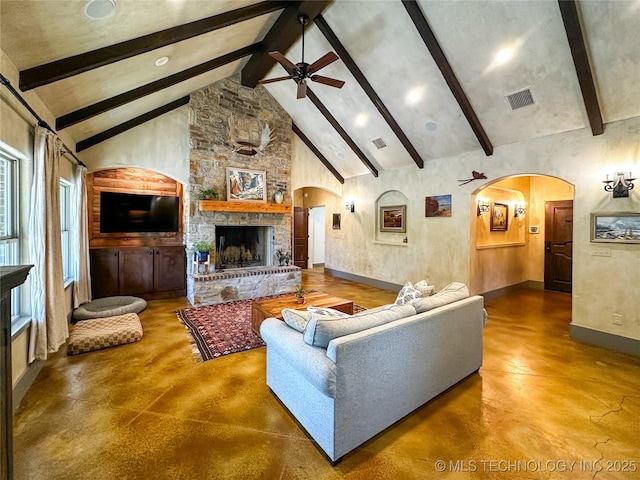 16012 N 145th Ave, Collinsville, OK 74021 - living room with arched walkways, finished concrete floors, beam ceiling, a ceiling fan, and a large fireplace