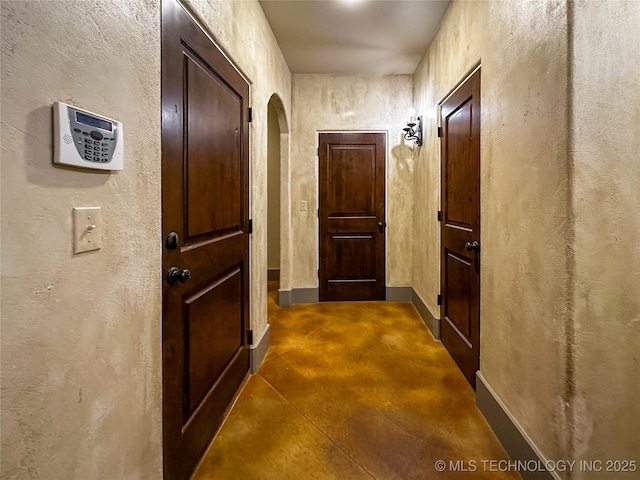 16012 N 145th Ave, Collinsville, OK 74021 - hall featuring finished concrete flooring, arched walkways, baseboards, and a textured wall