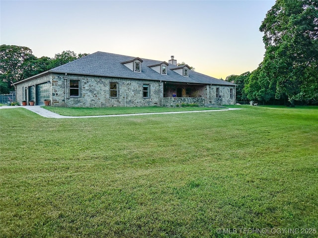 16012 N 145th Ave, Collinsville, OK 74021 - rear view of house featuring a garage, a lawn, stone siding, and a chimney