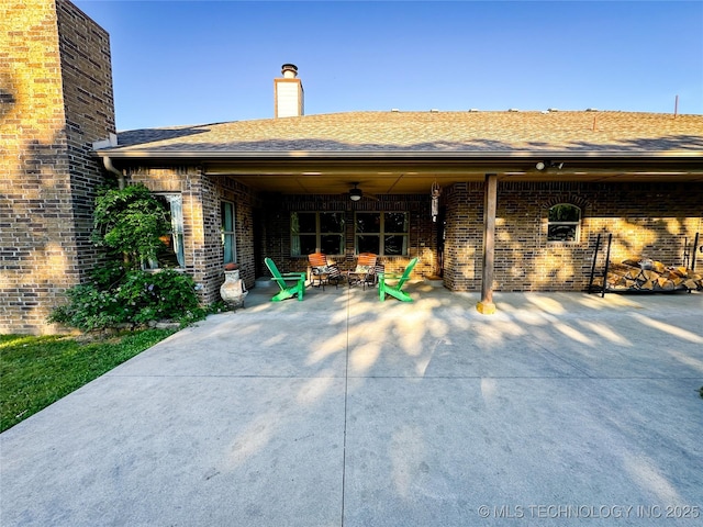 16012 N 145th Ave, Collinsville, OK 74021 - rear view of house featuring a chimney, brick siding, a patio area, and roof with shingles