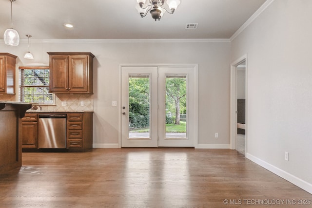 3200 Heritage Dr, Claremore, OK 74019 - kitchen featuring stainless steel dishwasher, healthy amount of natural light, a chandelier, brown cabinets, and crown molding