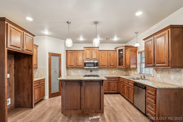 3200 Heritage Dr, Claremore, OK 74019 - kitchen with appliances with stainless steel finishes, brown cabinetry, a sink, light wood-style floors, and light stone countertops