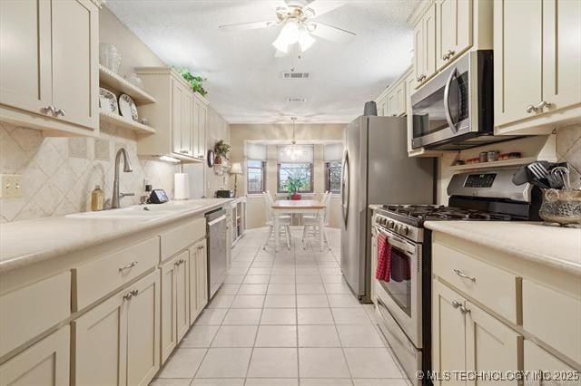 20941 E 102nd St S, Broken Arrow, OK 74014 - kitchen with stainless steel appliances, light tile patterned flooring, open shelves, light countertops, and ceiling fan