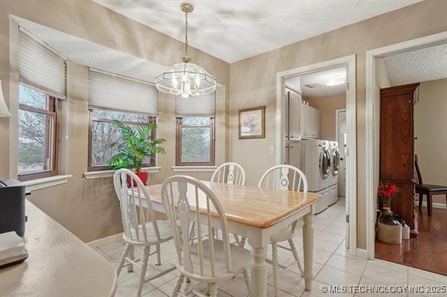 20941 E 102nd St S, Broken Arrow, OK 74014 - dining area with separate washer and dryer, light tile patterned floors, a chandelier, and baseboards