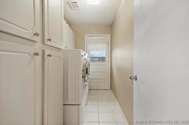 20941 E 102nd St S, Broken Arrow, OK 74014 - washroom with washer and clothes dryer, light tile patterned flooring, cabinet space, baseboards, and a textured ceiling