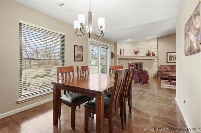 20941 E 102nd St S, Broken Arrow, OK 74014 - dining room with wood finished floors, a chandelier, baseboards, and a fireplace