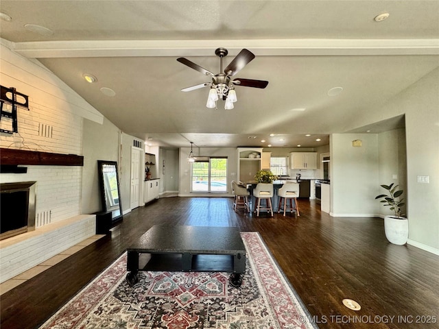 74232 S 320th Rd, Wagoner, OK 74467 - living room with dark wood-style flooring, a ceiling fan, baseboards, and a brick fireplace