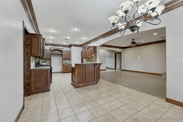 7083 E 85th St N, Owasso, OK 74055 - kitchen with arched walkways, crown molding, a chandelier, open floor plan, and tasteful backsplash